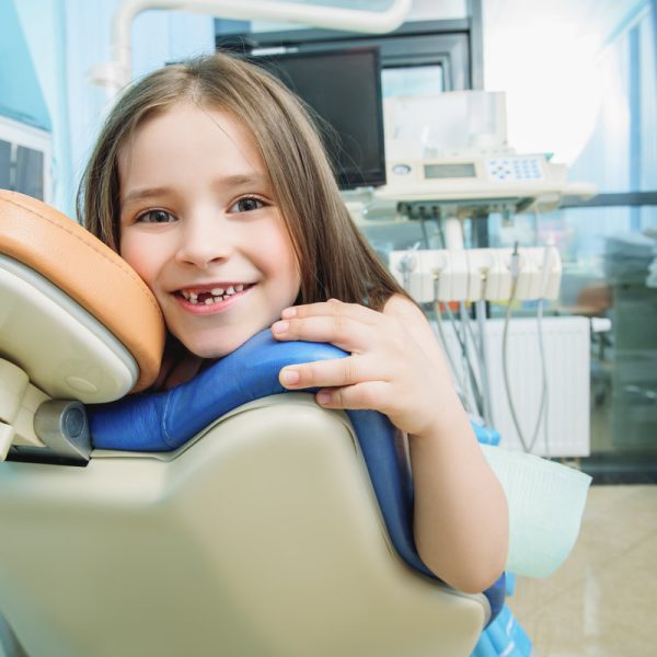 A portrait of a child girl in the cabinet of a dentist. Treatment, medicine, hospital.